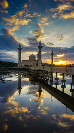 Reflection of bridge in river against sky