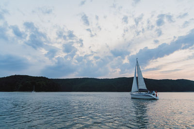 Sailboat sailing on sea against sky