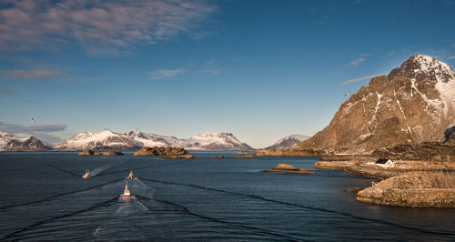 Scenic view of sea by mountains against sky