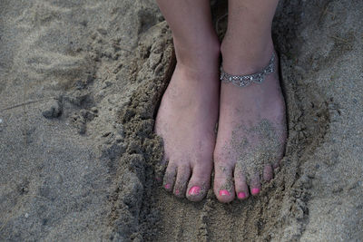 Low section of woman on sand at beach