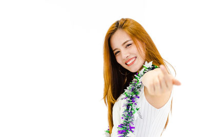 Young woman smiling against white background