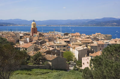 Cityscape by sea against sky