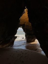View of beach seen through cave