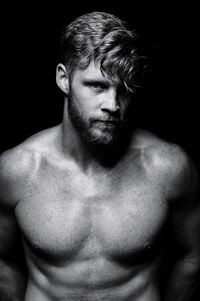 Portrait of shirtless man against black background