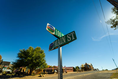 Low angle view of road sign against blue sky