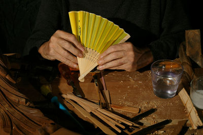 Carpentry craftsman's hands building a fan, unrecognisable.