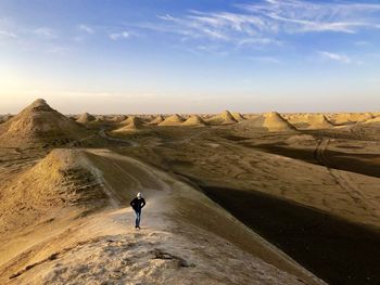 High angle view of girl standing at desert against sky