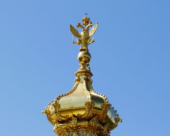 Low angle view of angel statue against clear blue sky