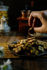 Cropped hand of woman holding cookies on table as a festive concept such as eid or christmas