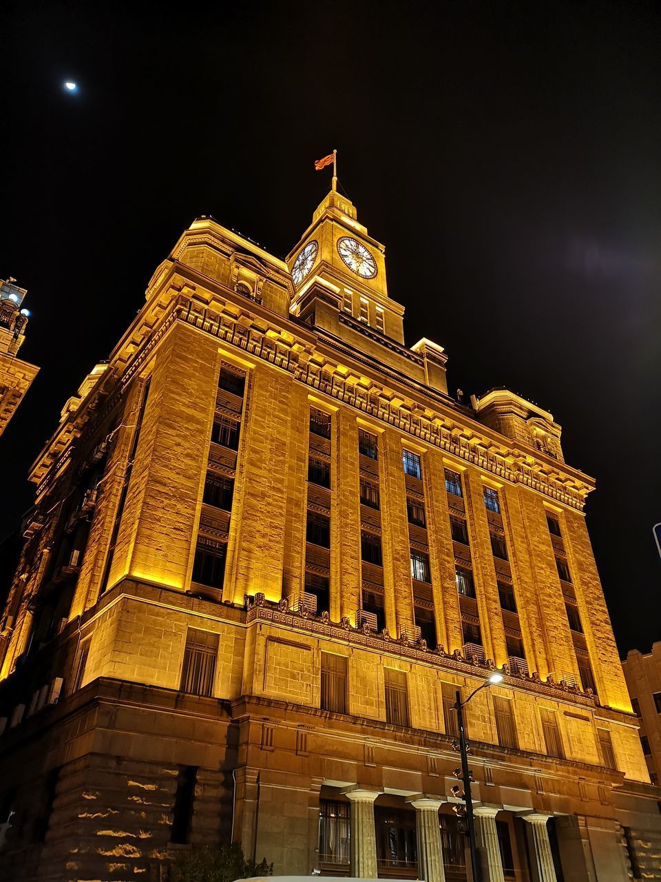 LOW ANGLE VIEW OF ILLUMINATED BUILDINGS AT NIGHT