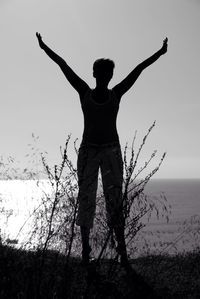 Low angle view of young woman standing at beach