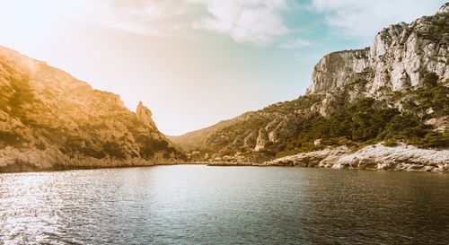 Scenic view of lake by mountains against sky