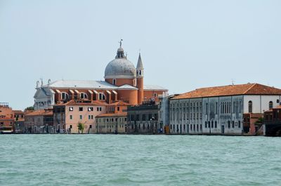 View of sea and buildings against clear sky