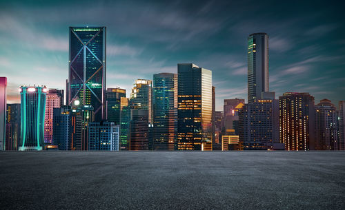 View of illuminated buildings in city against sky