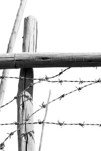 Low angle view of barbed wire against clear sky