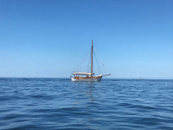 Wooden boat captured at sea outside marstrand. pater noster lighthouse can be spotted in the horizon