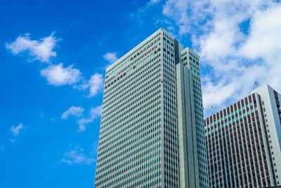 Low angle view of modern buildings against blue sky