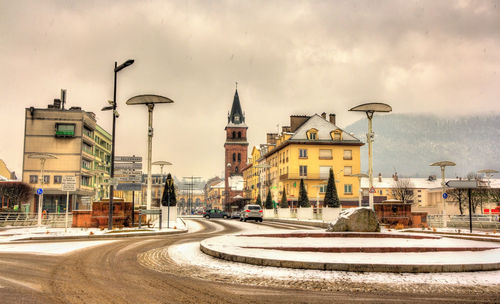 Buildings in city against cloudy sky