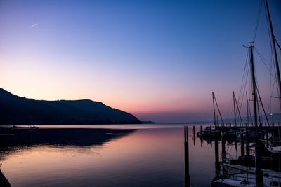 Sailboats in sea at sunset