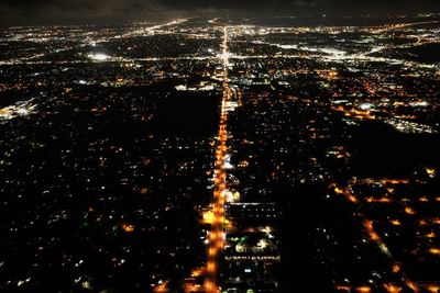 High angle view of illuminated city against sky at night