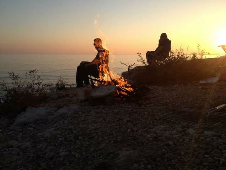 sunset, sea, sky, horizon over water, water, beach, sun, rock - object, clear sky, tranquility, sitting, nature, sunlight, tranquil scene, scenics, abandoned, full length, lifestyles