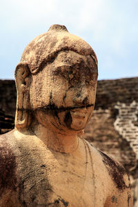 Low angle view of buddha statue against sky