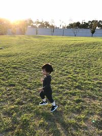 Rear view of boy standing on field