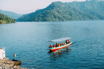 High angle view of people in ferry boat on lake