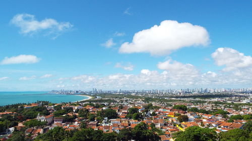 High angle view of townscape by sea against sky