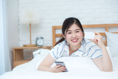 Portrait of smiling young woman using mobile phone