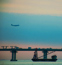 Airplane flying over sea against sky