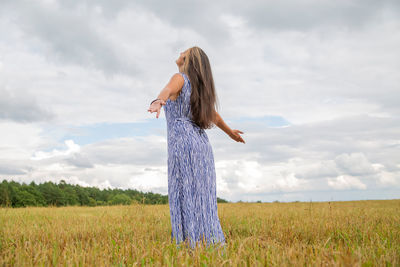 Rear view of woman standing on field