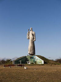 Jesus christ statue on field against sky