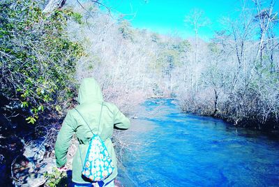 Rear view of woman walking by water