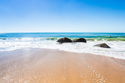 Scenic view of beach against clear sky