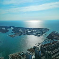 High angle view of sea by buildings against sky