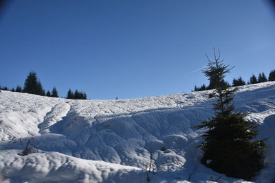 Scenic view of snowcapped landscape against clear blue sky