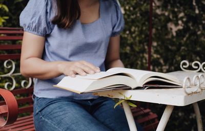 Midsection of woman reading book