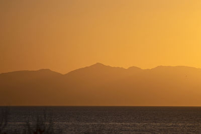 Scenic view of sea against romantic sky at sunset