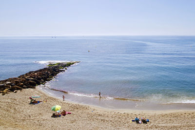 People on beach against sky