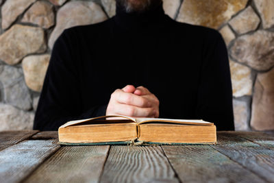 Close-up of person holding book on table