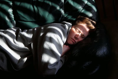 High angle view of woman sleeping on sofa at home