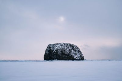 View of rock formation in sea against sky