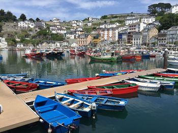 Boats moored at harbor against sky