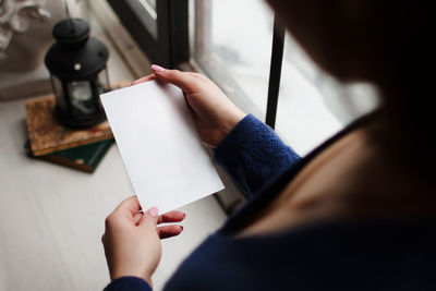 High angle view of woman hand holding paper