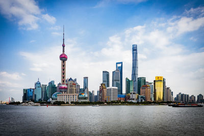 View of buildings in city against cloudy sky