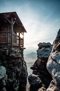 Built structure on rock by building against sky