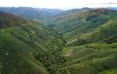 Scenic view of valley and mountains against sky