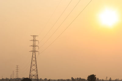 Low angle view of electricity pylons against clear sky