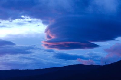 Scenic view of mountains against cloudy sky